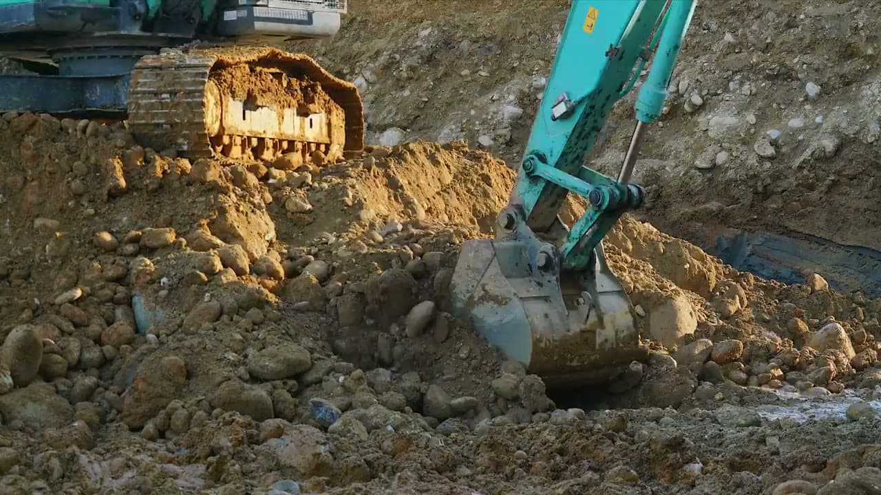 Beispielbild: Bagger bewegt Erde und Steine auf einer Baustelle.